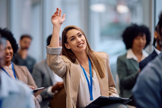 Entrepreneur raising her arm to ask question.