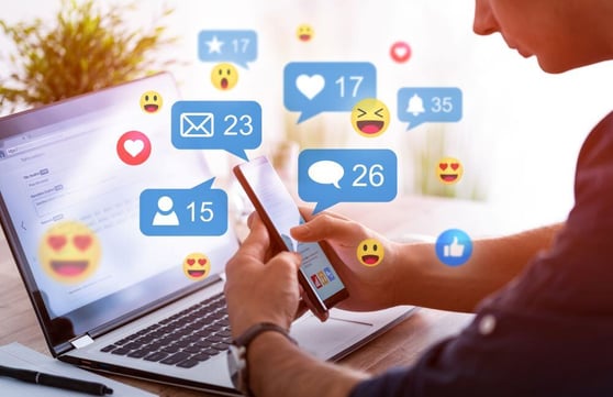 Person on their phone with social media icons flying around.