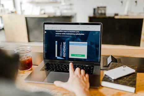Person analyzing website performance metrics for A/B testing for landing pages on a laptop.