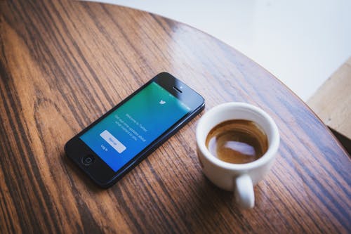 Phone and Expreso Cup on a Wooden Table