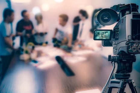Video camera filming a marketing team working together on video marketing content creation.